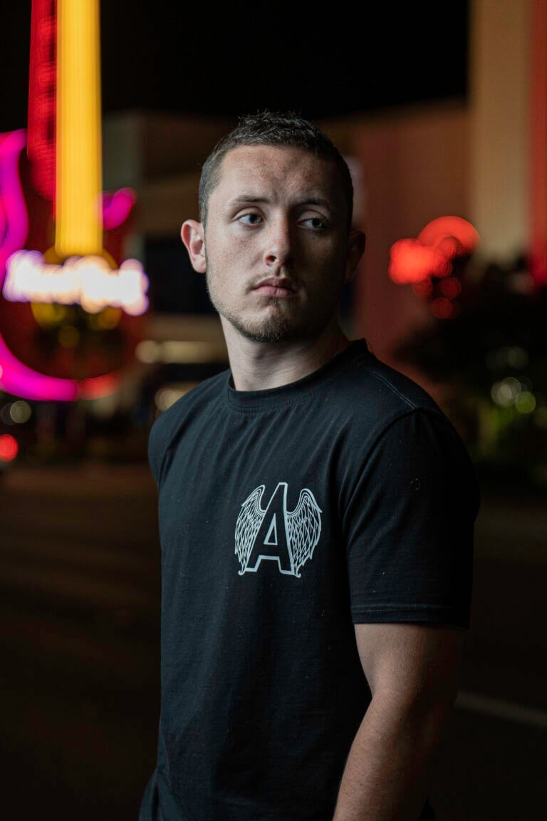 Person standing near colorful lights.