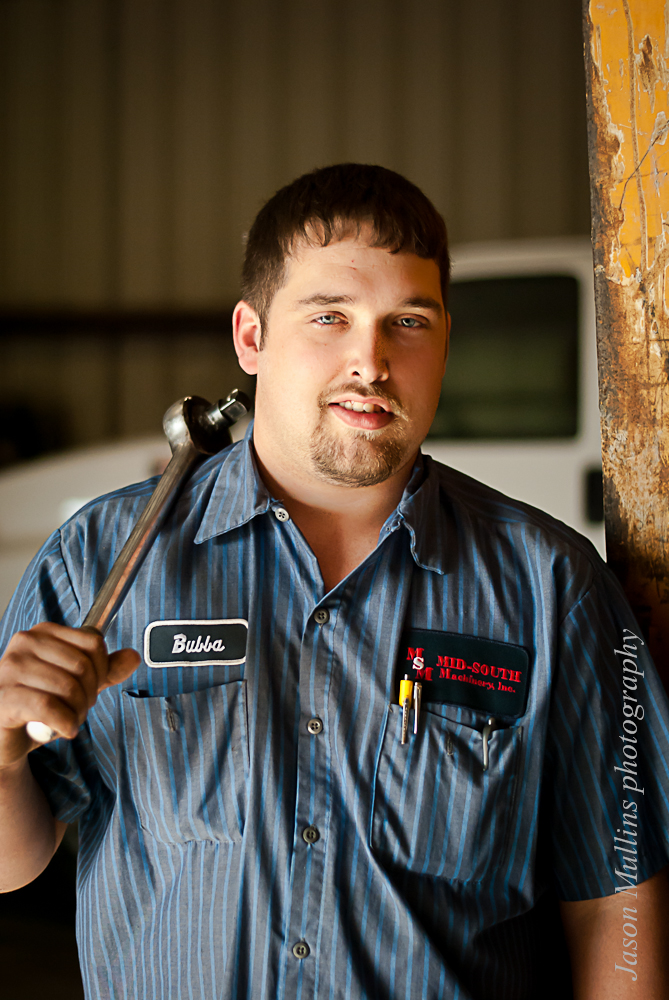 Man holding a wrench in workshop.